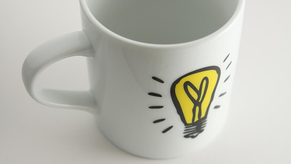 White mug with white background. Idea symbol is on the mug.