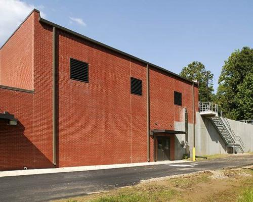 Exterior photo looking up at 2 story red brick facility. Exterior stairs let up to the second floor.